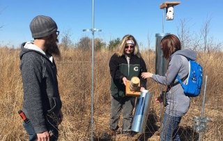 Adam & Sara Wilson and Carole Blaser putting up bird boxes